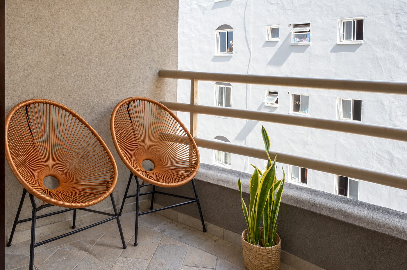 Cadeiras de varanda com planta natural, à luz do dia