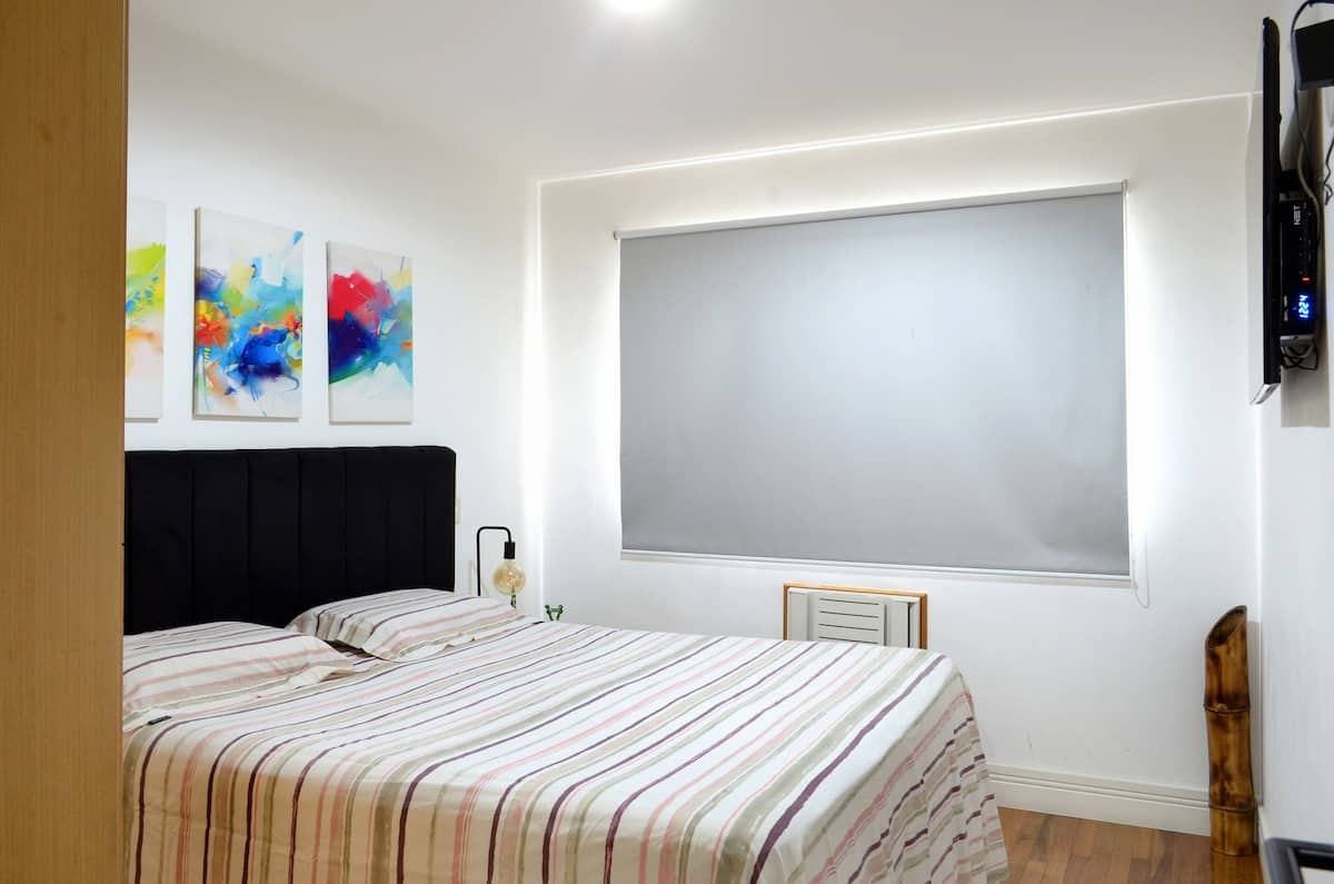 Quarto com cama King e cortina blackout